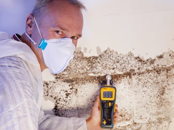 A man inspects a wall for damages in Florida