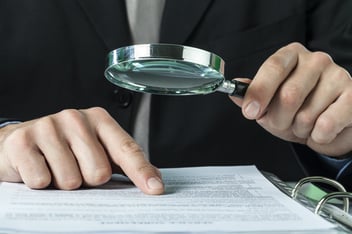 A public adjuster views an insurance claim under a magnifying glass