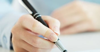A pen writing on an insurance form