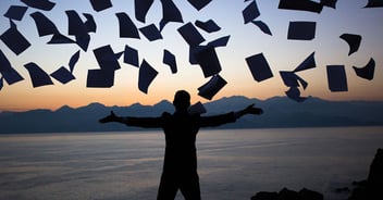 An individual throwing paperwork into the air, representing churn and burn insurance adjusting