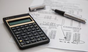 A calculator and documents, processing student debt and buying a home