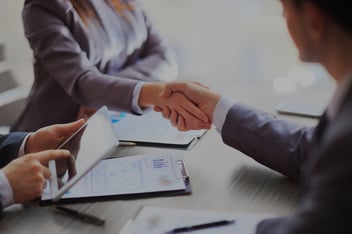 A public adjuster and client shake hands after completing an agreement