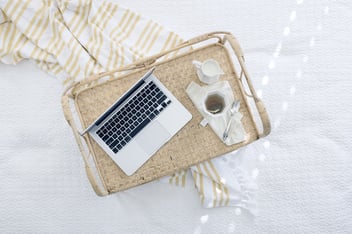 A laptop and coffee sitting on a kitchen island, used to run a home business